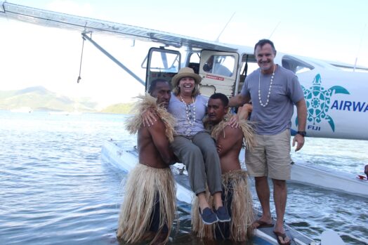 Locals carrying a woman off a seaplane in Fiji