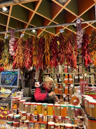 a woman selling peppers in La Boqueria in Barcelona