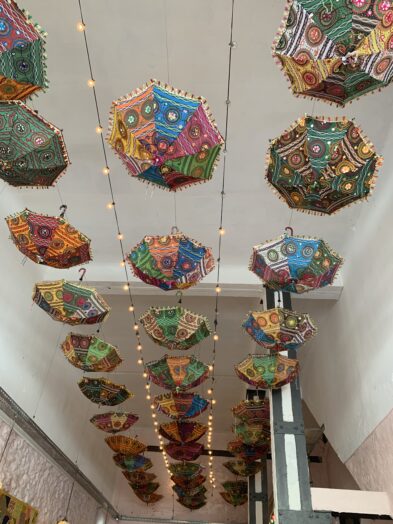 Colorful umbrellas hanging from the ceiling of a restaurant