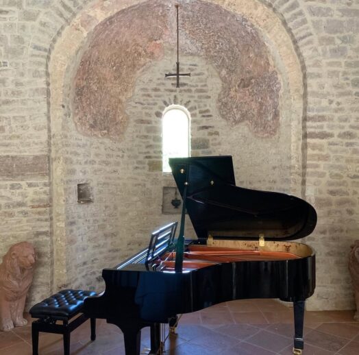 A grand piano in the chapel at a vineyard in Italy.