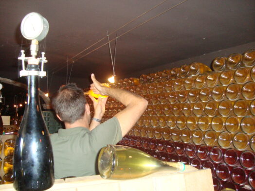 a man turning bottles of wine in Tuscany