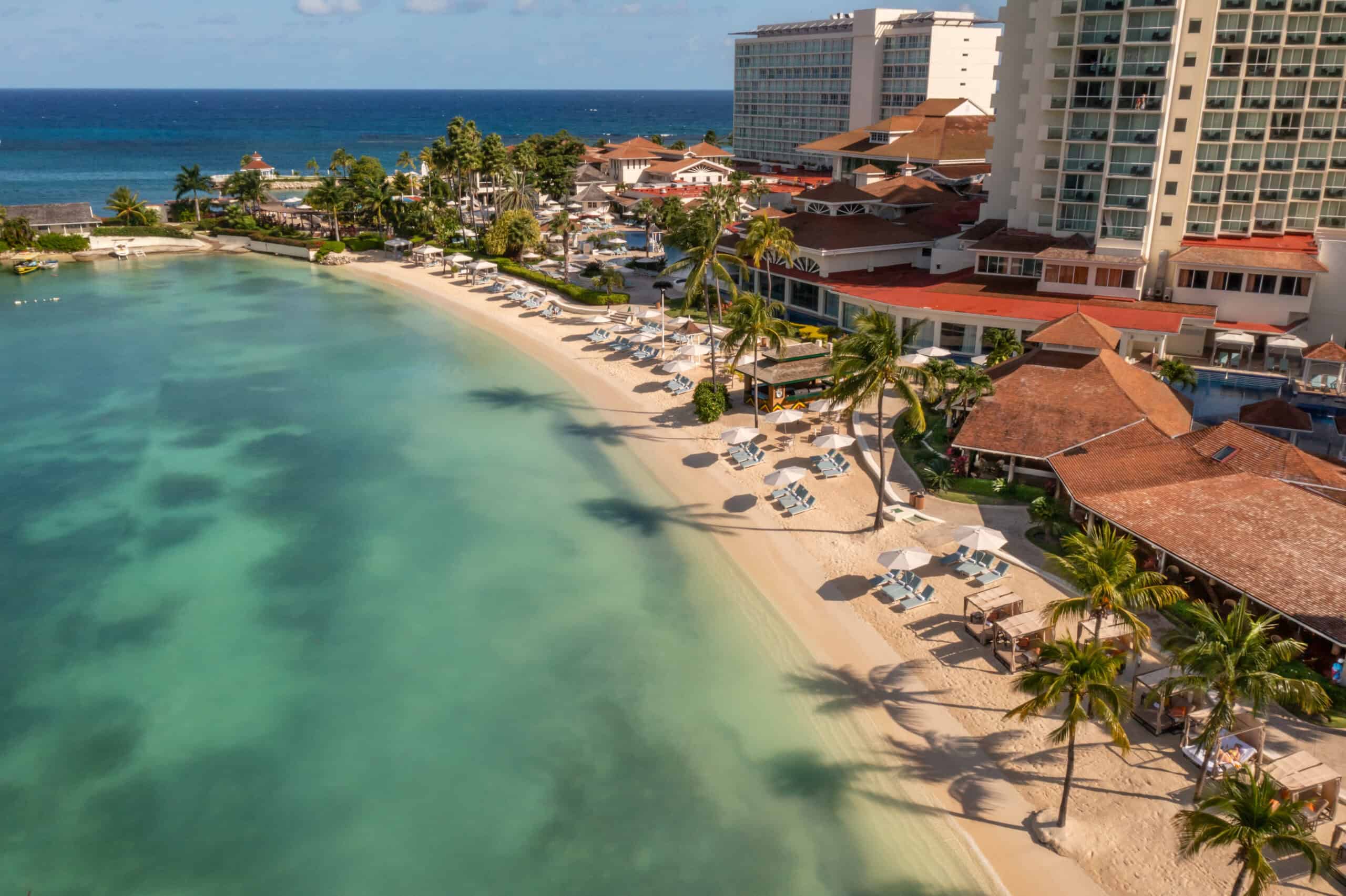 Beachfront Caribbean resort with clear waters, palm trees, and family-friendly amenities.