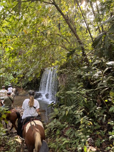 riding horses beneath a waterfall in la fortuna