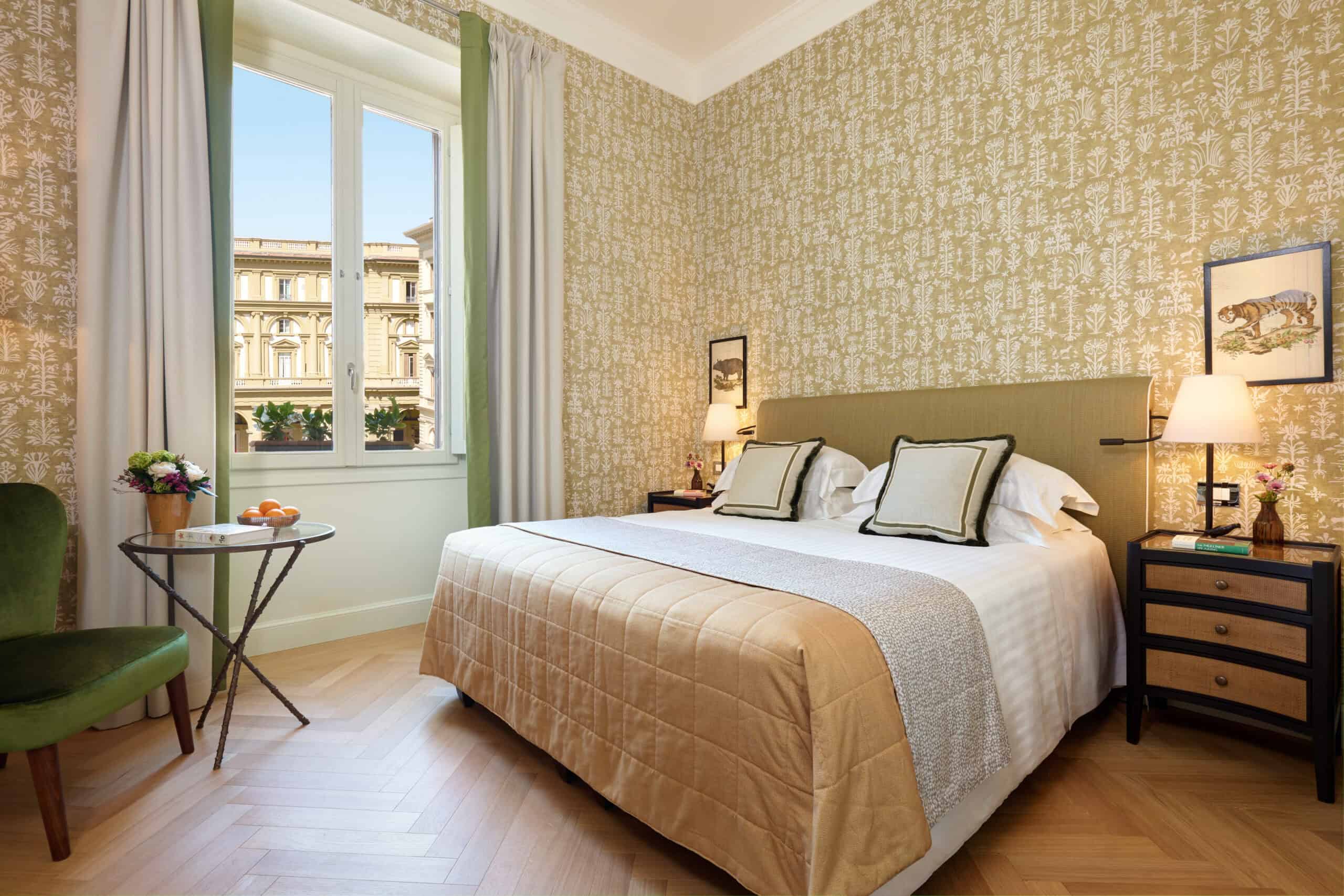 Elegant hotel bedroom with stylish decor, large window, and cityscape view for a comfortable stay.