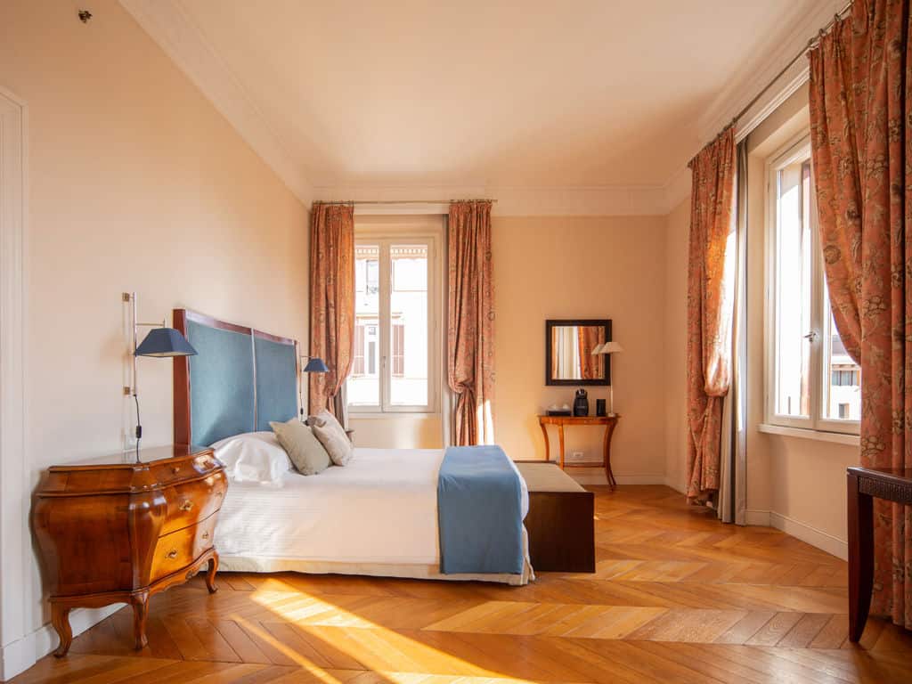 Bright and inviting bedroom featuring large windows and classic decor.