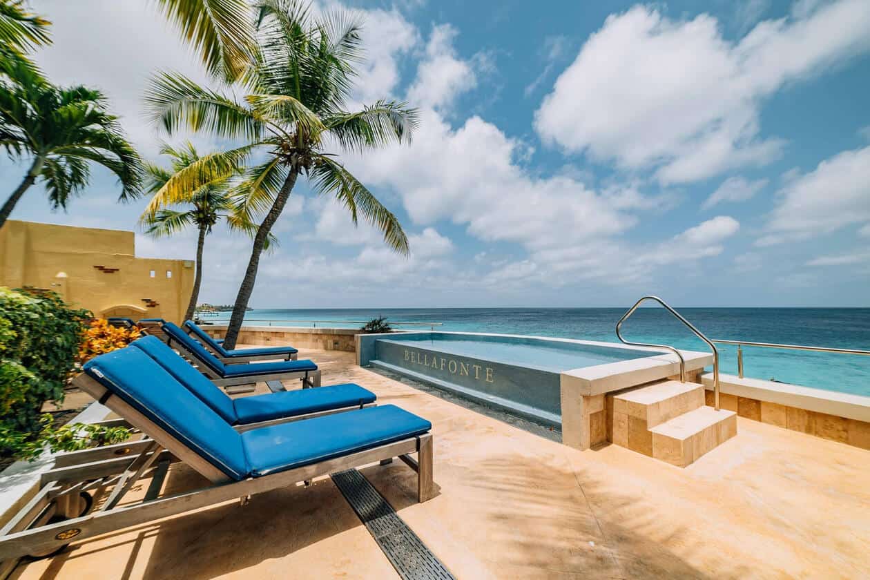 Poolside relaxation at Bellafonte resort with ocean view and lounge chairs.