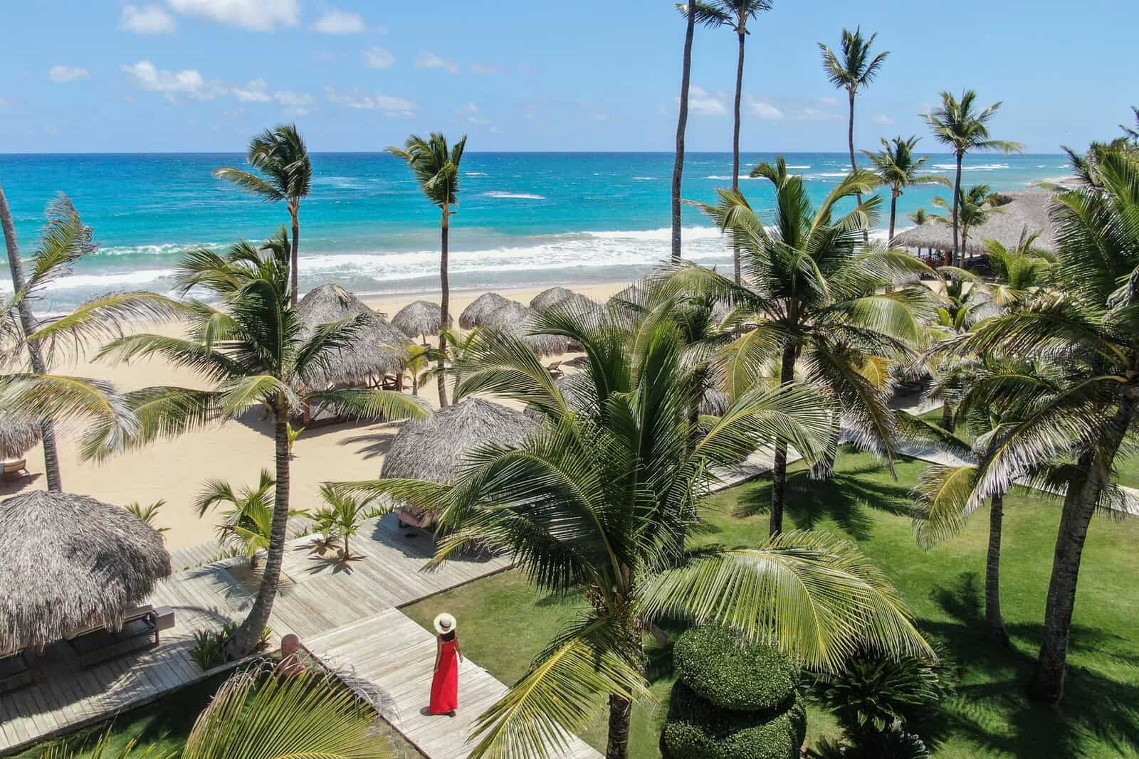 Beach view with palm trees and thatched umbrellas in Punta Cana, Dominican Republic.