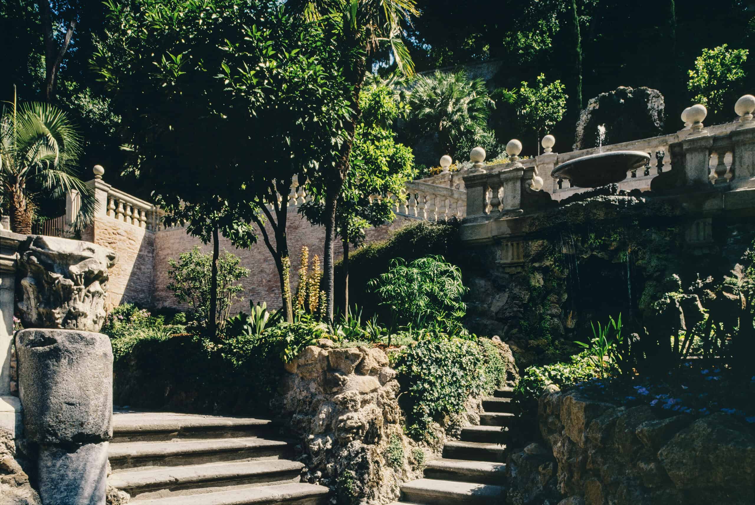 Serene garden with stone steps, lush plants, and decorative balustrades in a tranquil outdoor settin.