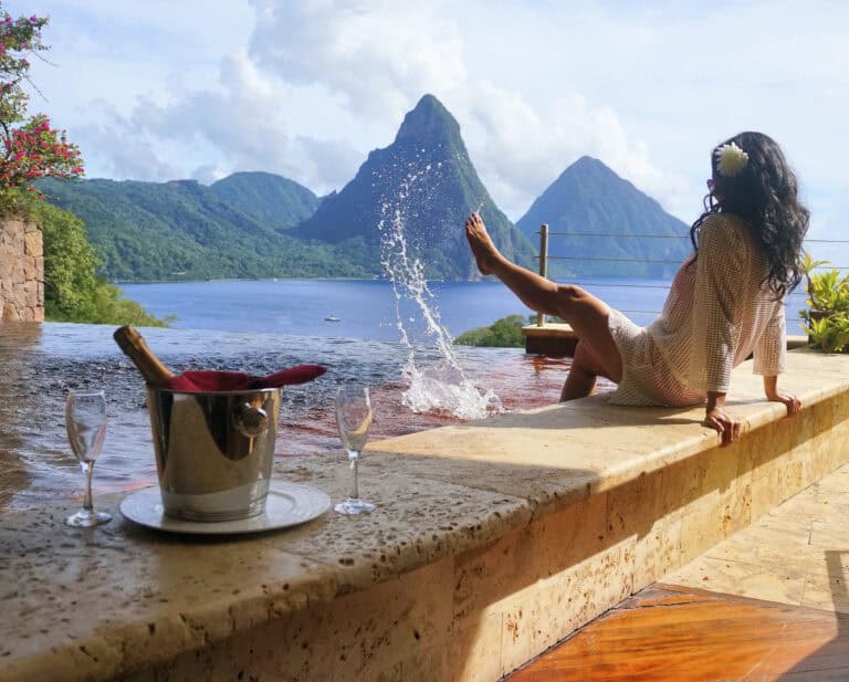Relaxing woman enjoying mountain lake view from infinity pool in tropical paradise.