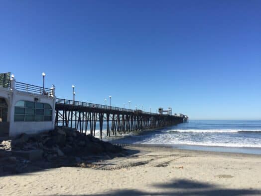Scenic Florida beach with pier and clear blue sky.