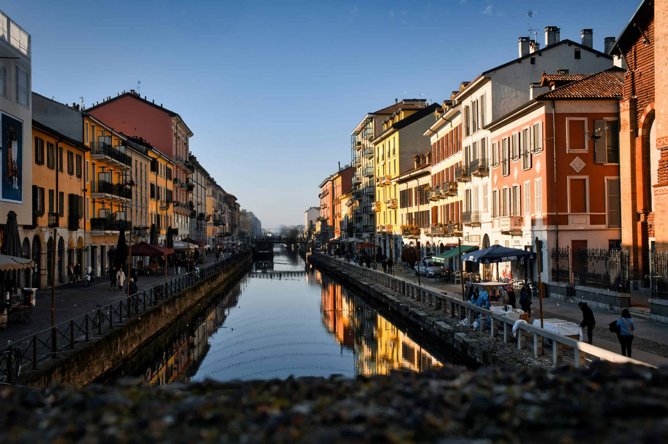 Milan, Italy canal view with vibrant historic buildings and reflections in the water.