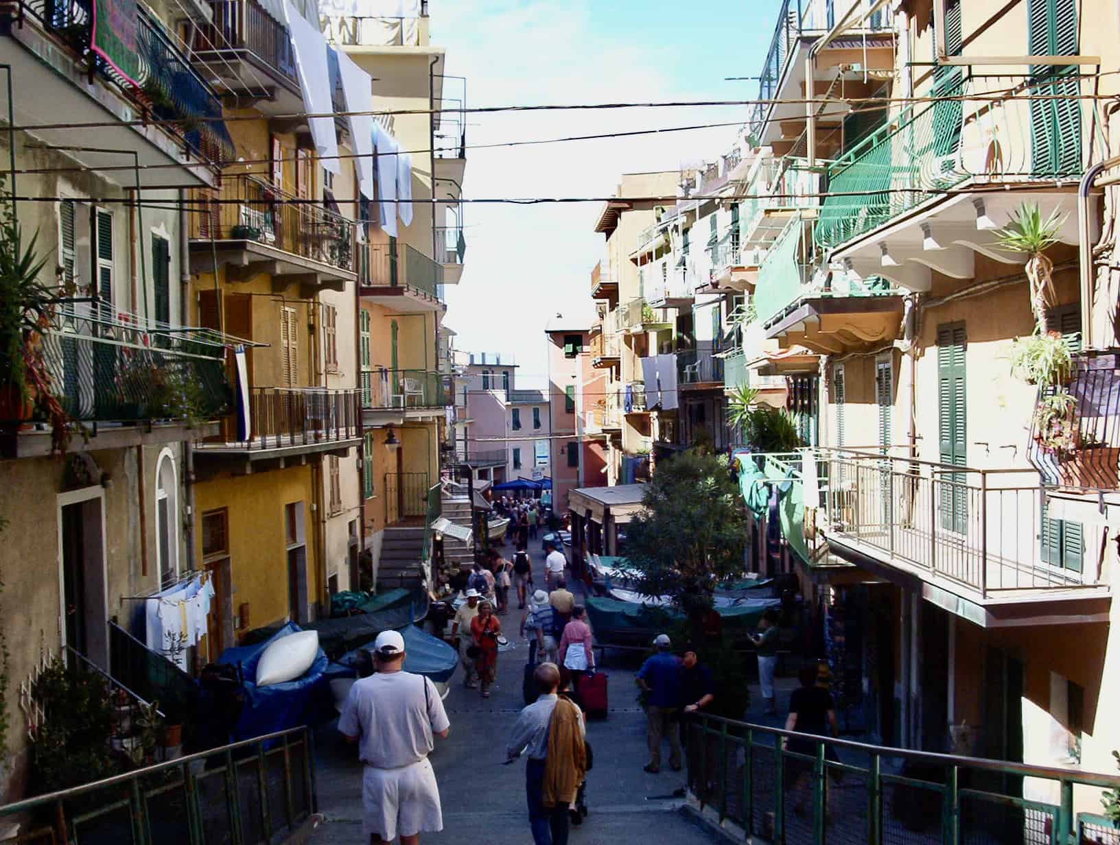 Colorful Italian apartment buildings with balconies and laundry hanging outside.