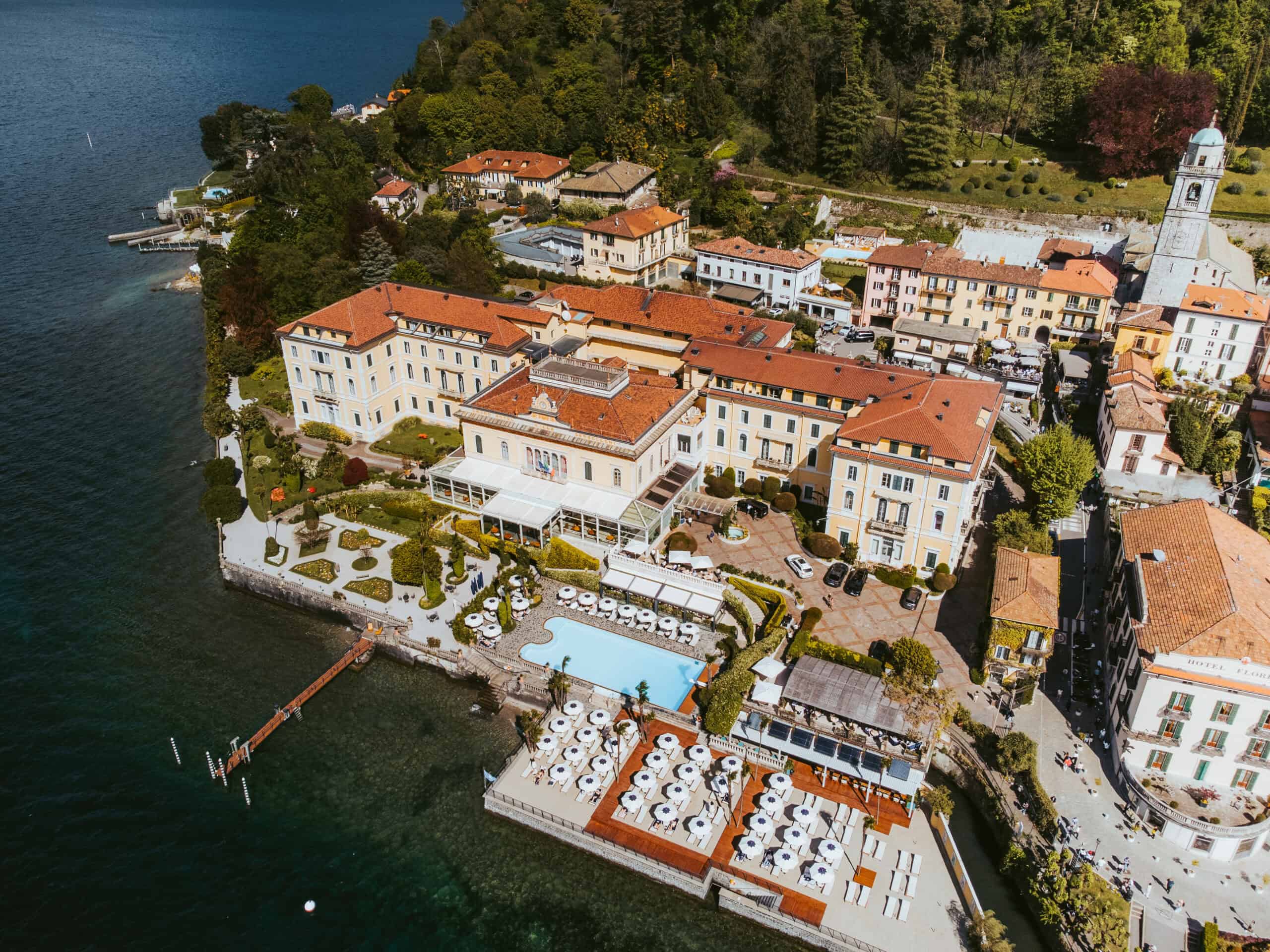 Lakeside hotel on Lake Como featuring a pool, outdoor seating, and stunning mountain views, perfect.