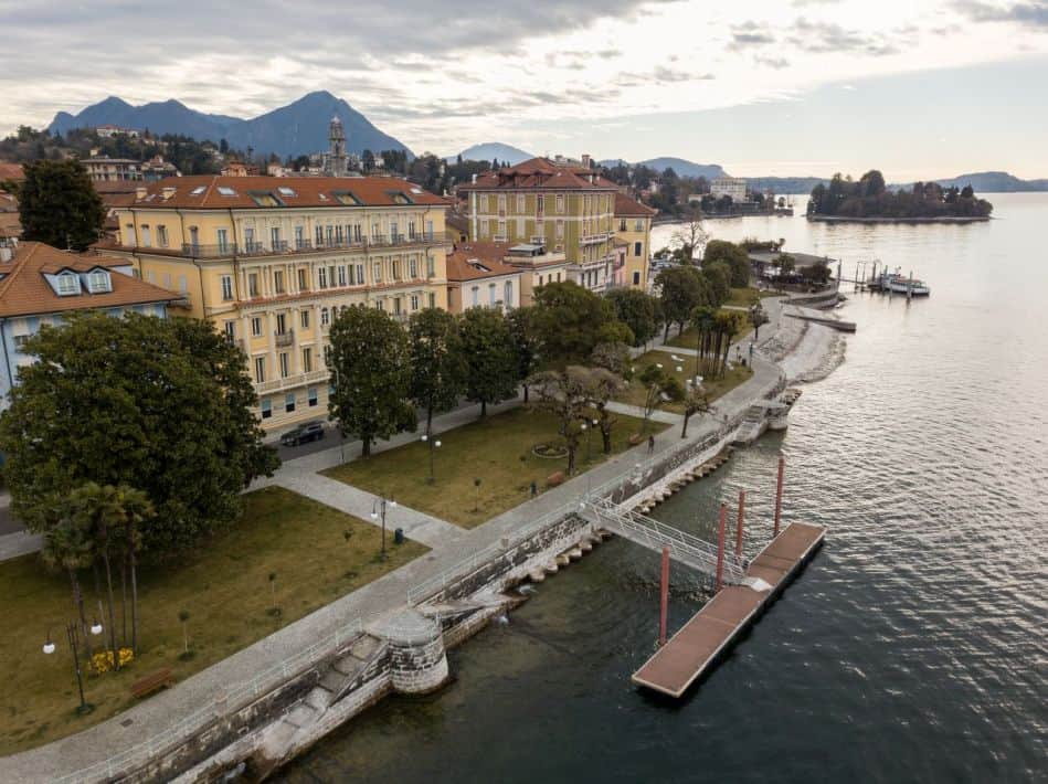 Scenic view of Lake Maggiore with colorful historic buildings and lush greenery in a popular travel.