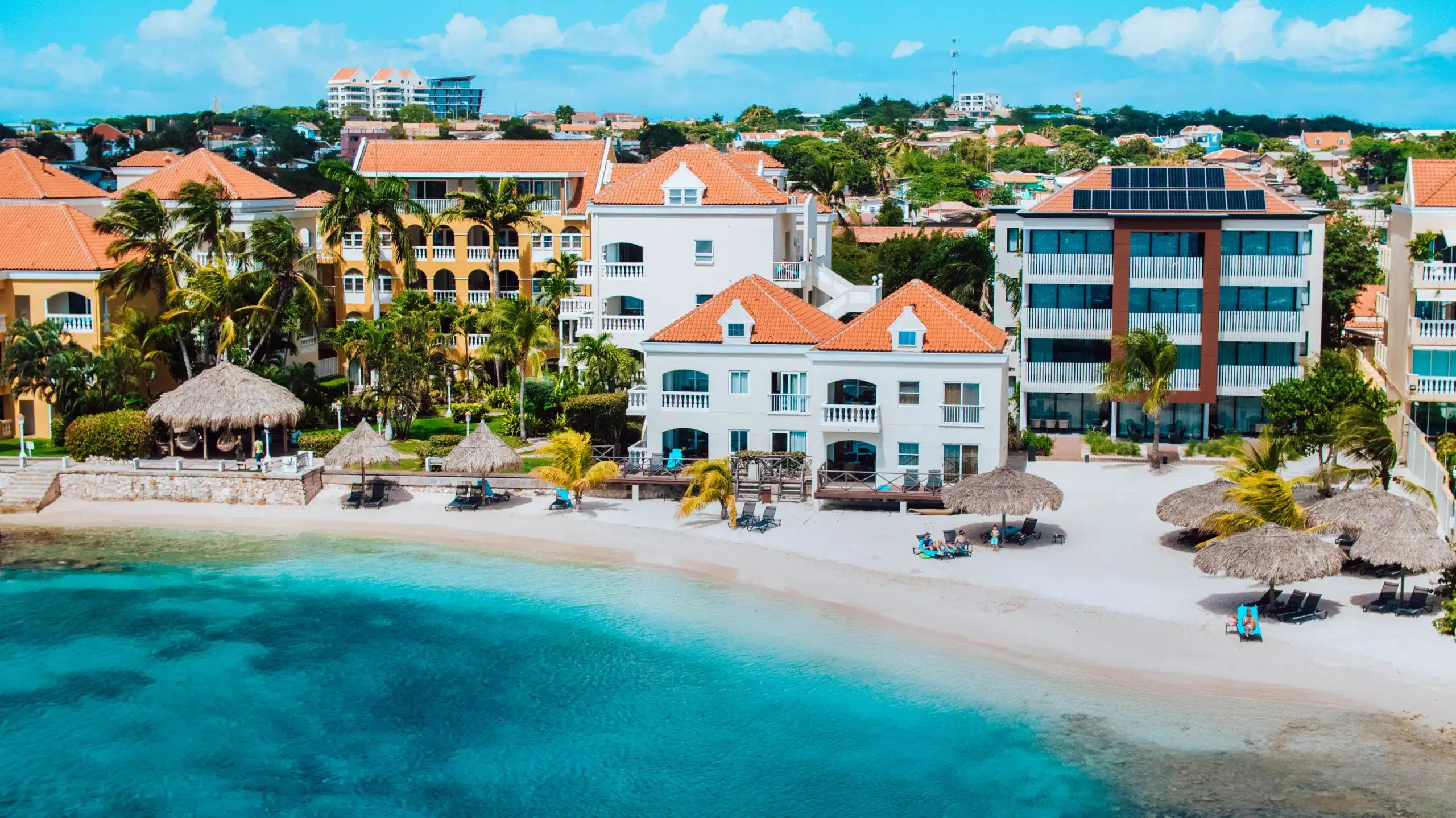 Beachfront resort in Cancun with vibrant buildings, white sandy beach, and turquoise waters, perfect.