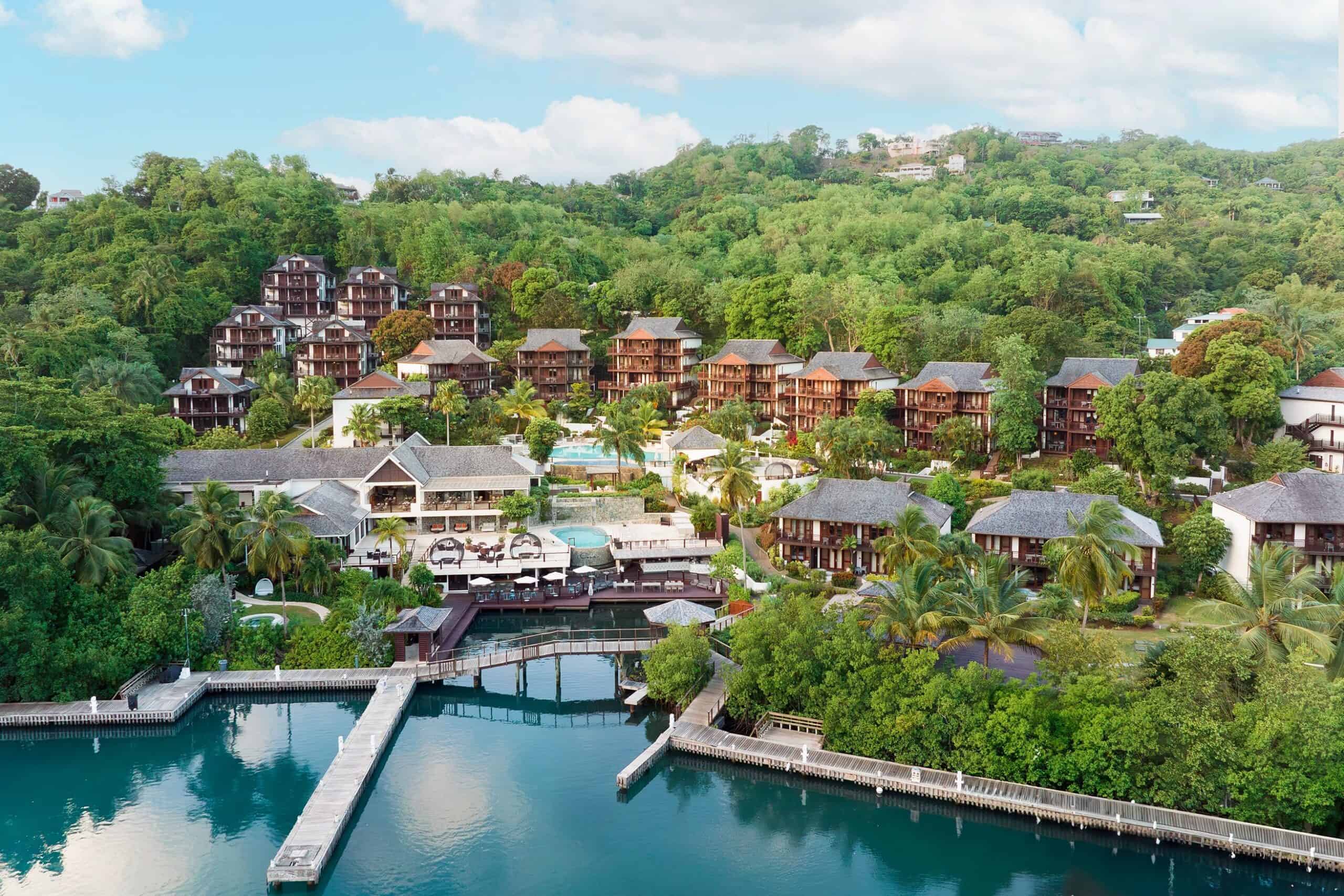 Luxury waterfront resort with hillside villas, tropical gardens, and scenic views of the water.
