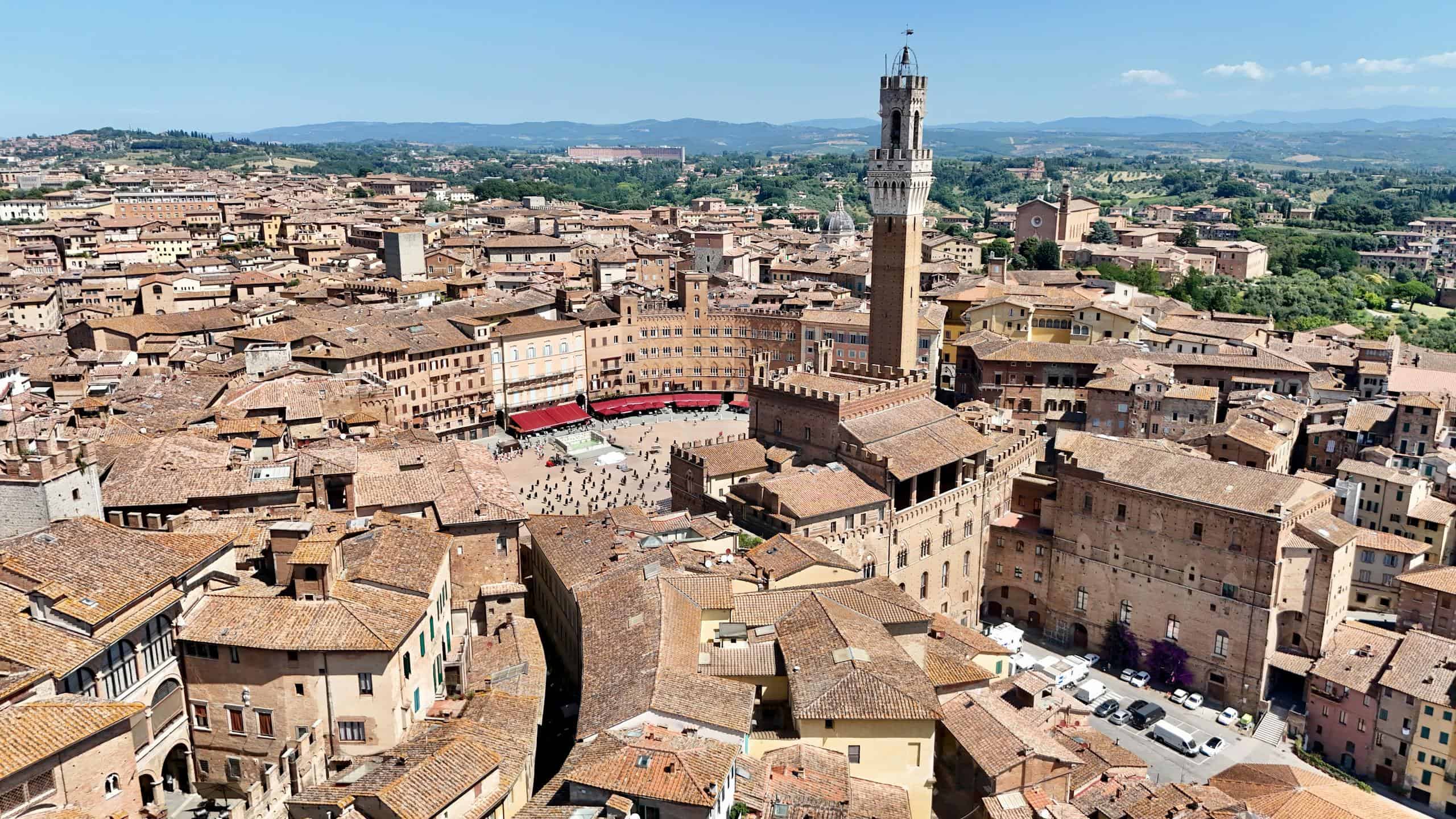 Aerial view of Florence, Italy, showcasing historic architecture, the Palazzo Vecchio tower, and ter.