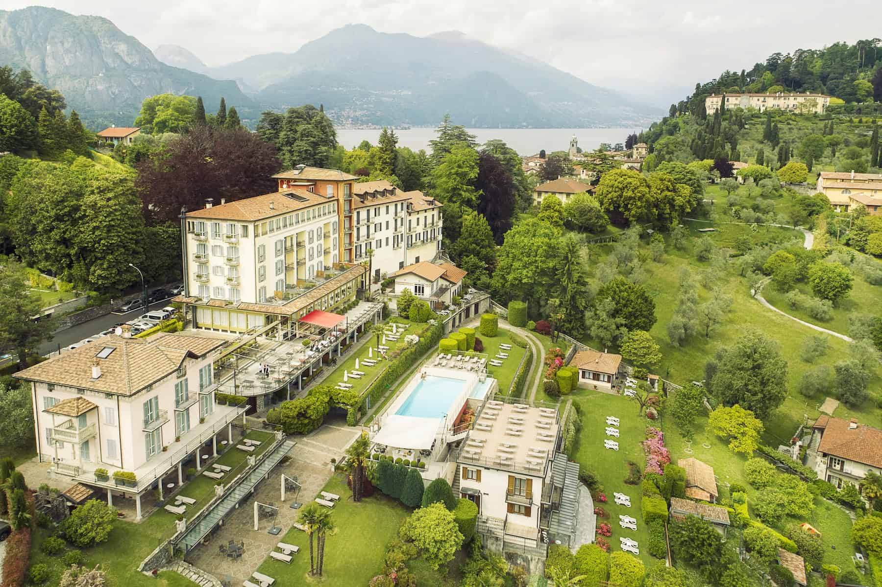 Elegant Lake Como hotel surrounded by lush gardens and scenic views.