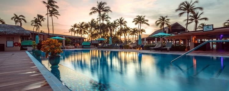Relaxing tropical resort pool with palm trees and sunset sky, perfect for vacation relaxation and le.