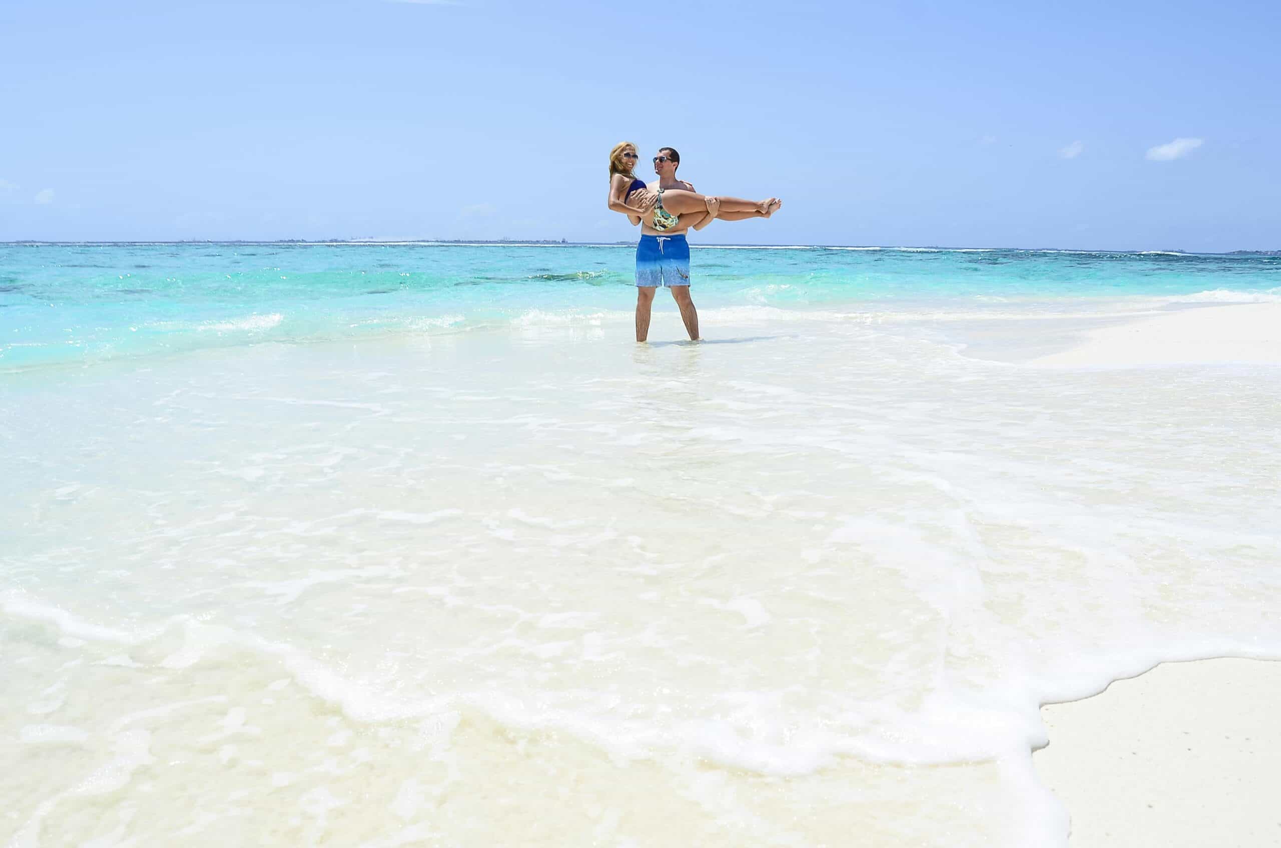 Beach couple enjoying a romantic moment in clear turquoise waters.