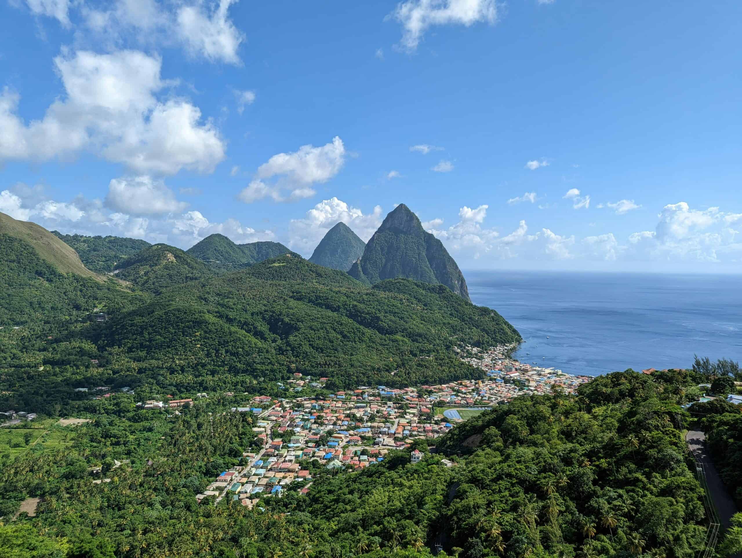 Tropical mountain landscape with lush greenery, a coastal village, and the ocean in the background,.