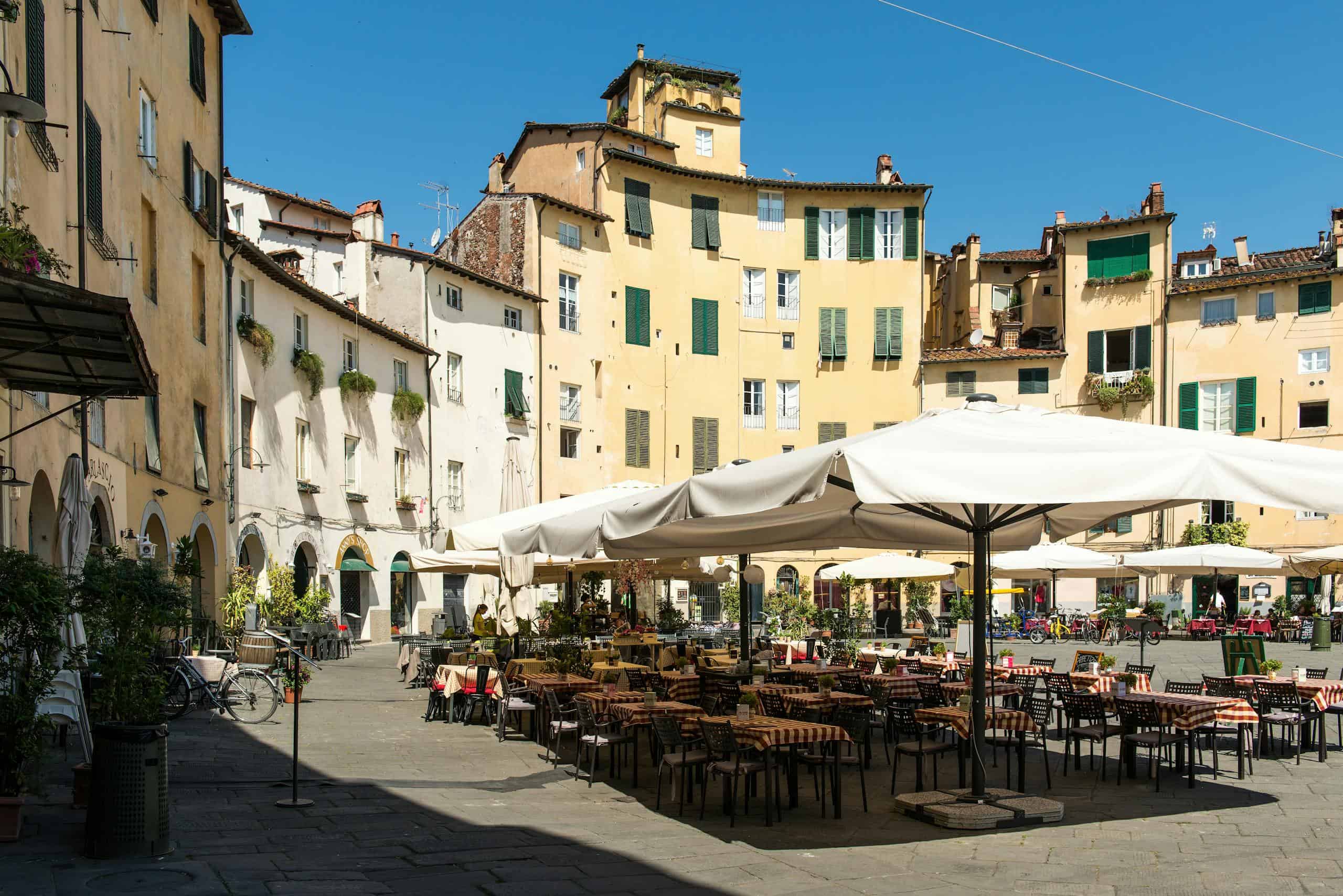 Historic Italian town square with outdoor seating, colorful buildings, and vibrant atmosphere. Perfe.