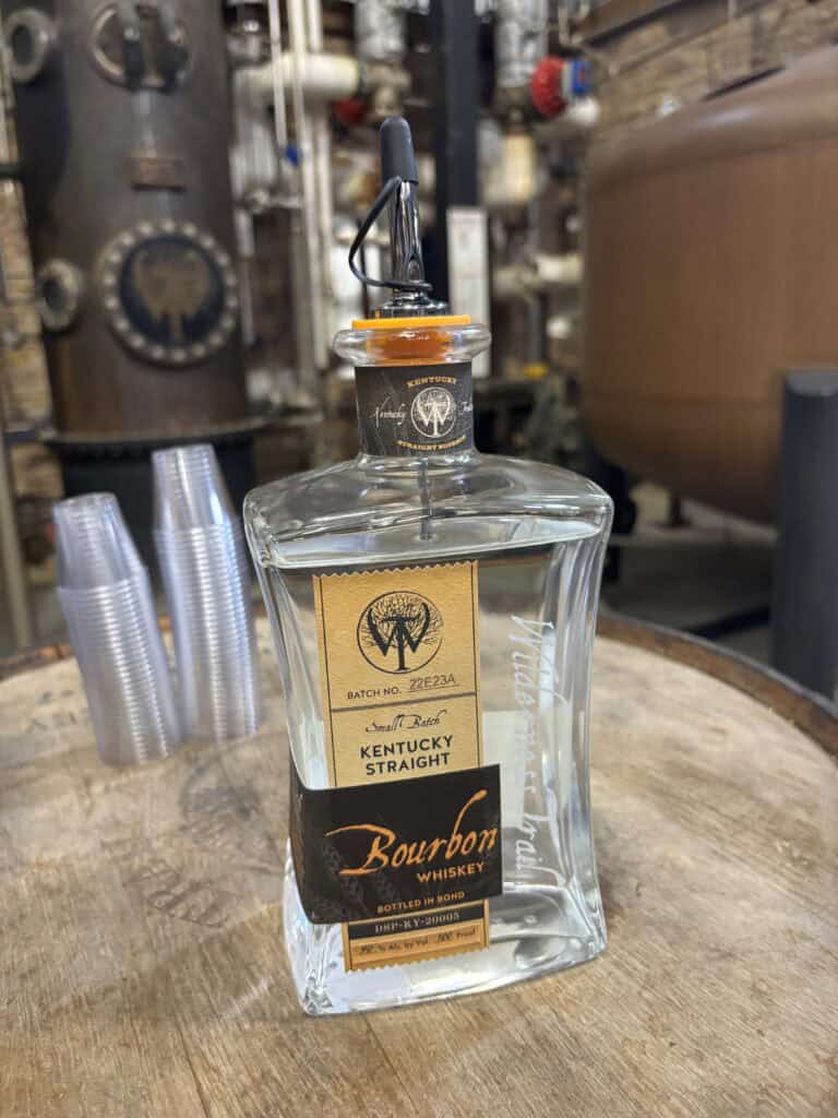 Close-up of Kentucky Straight Bourbon Whiskey bottle in distillery setting.