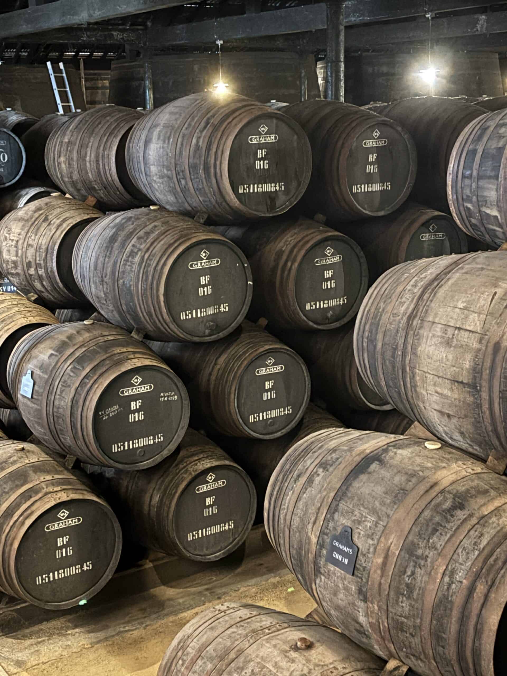 Stacked wine barrels in a cellar for aging wine.